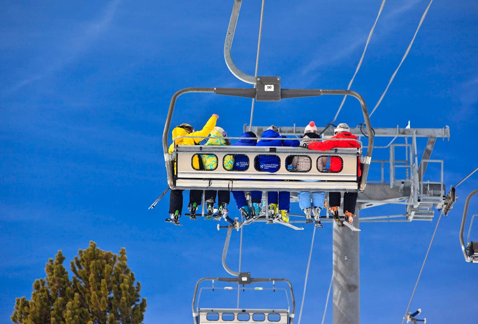 Skiers riding a Grandvalira chairlift