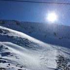 Sunshine behind the mountains on a bluebird day. Looking across to the Gaig black run