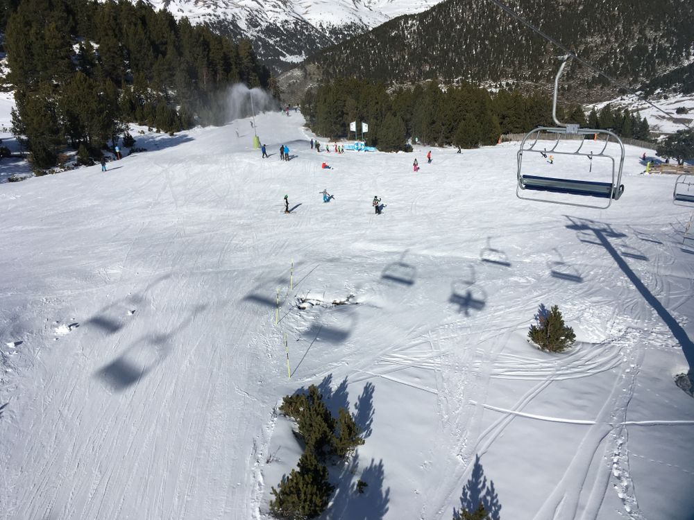Groomed runs and chairlift shadows under the TSF4 Planell de la Font